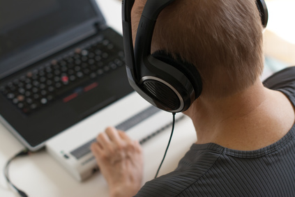 Mensch mit Headset und Hand auf Braillezeile